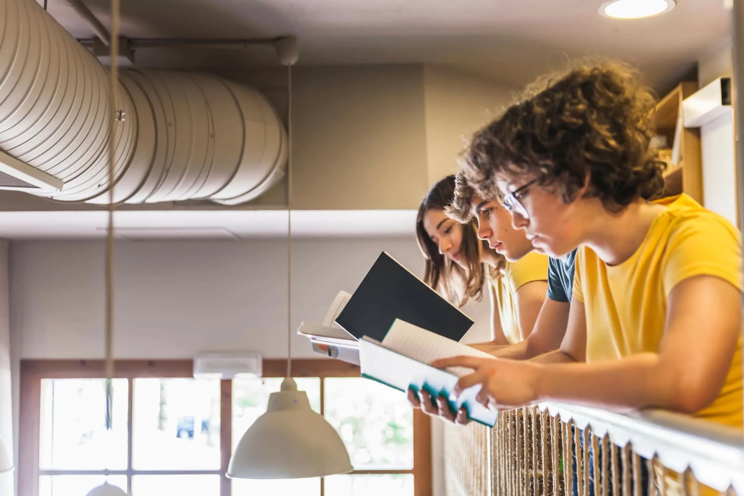 Leerlingen aan het werk in een klaslokaal met zichtbare ventilatiekanalen langs het plafond